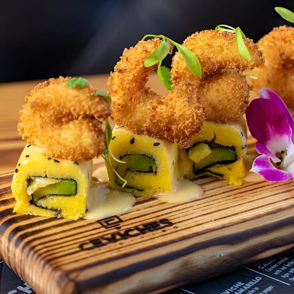 Peruvian sushi rolls with fried shrimp, avocado, and yellow sauce, garnished with a purple orchid.