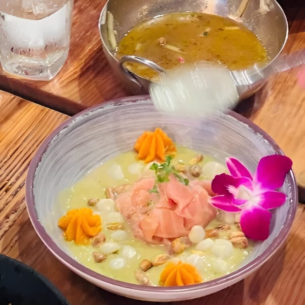 Peruvian ceviche with fish, corn, sweet potato puree, and a purple orchid garnish.