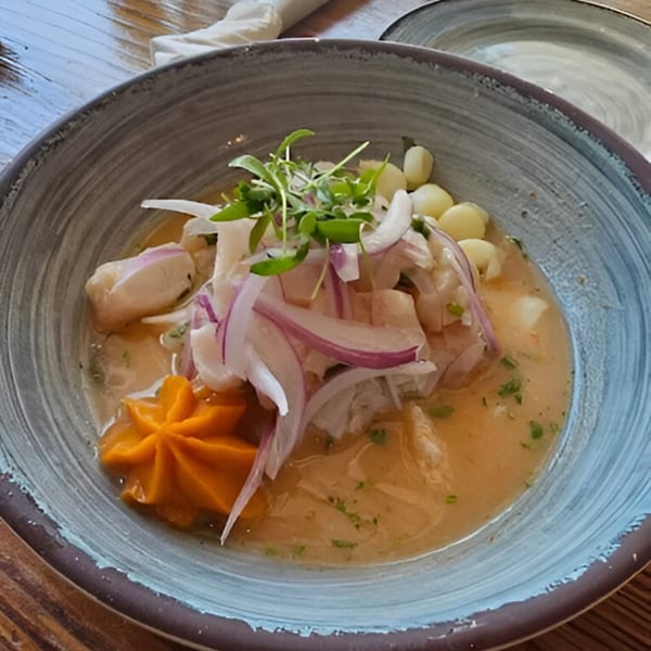 Peruvian ceviche with fish, red onions, corn, and a swirl of orange sweet potato puree.